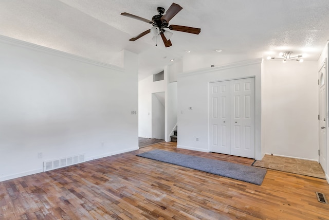 interior space featuring hardwood / wood-style floors, lofted ceiling, ceiling fan, a textured ceiling, and a closet