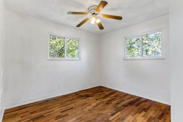 spare room featuring hardwood / wood-style flooring, ceiling fan, and a wealth of natural light