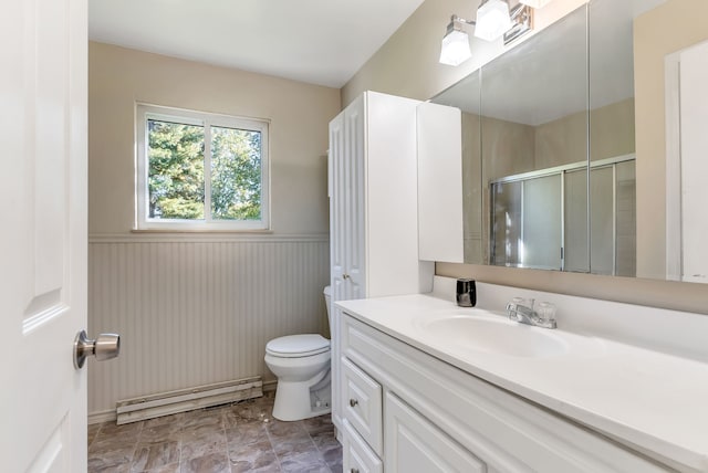 bathroom featuring vanity, a shower with shower door, and toilet