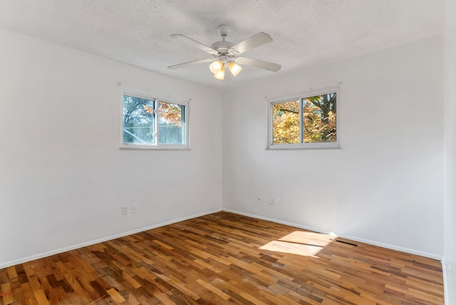 unfurnished room with ceiling fan, a textured ceiling, and hardwood / wood-style flooring