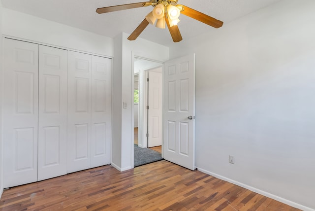 unfurnished bedroom featuring hardwood / wood-style floors, ceiling fan, a textured ceiling, and a closet