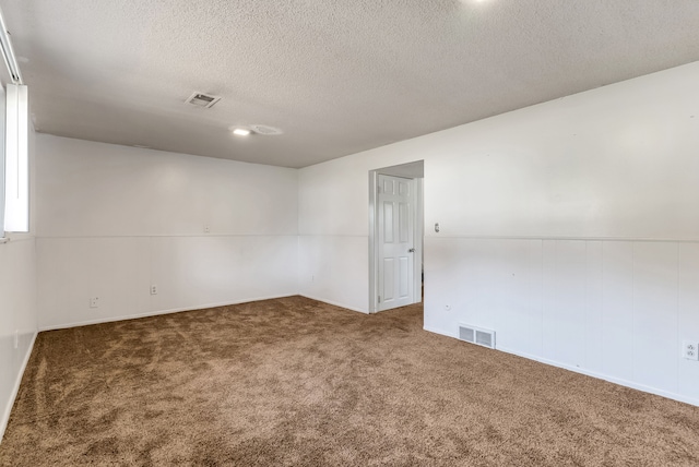 unfurnished room with dark carpet and a textured ceiling