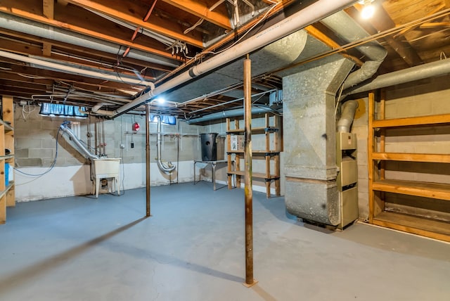 basement with heating unit and sink