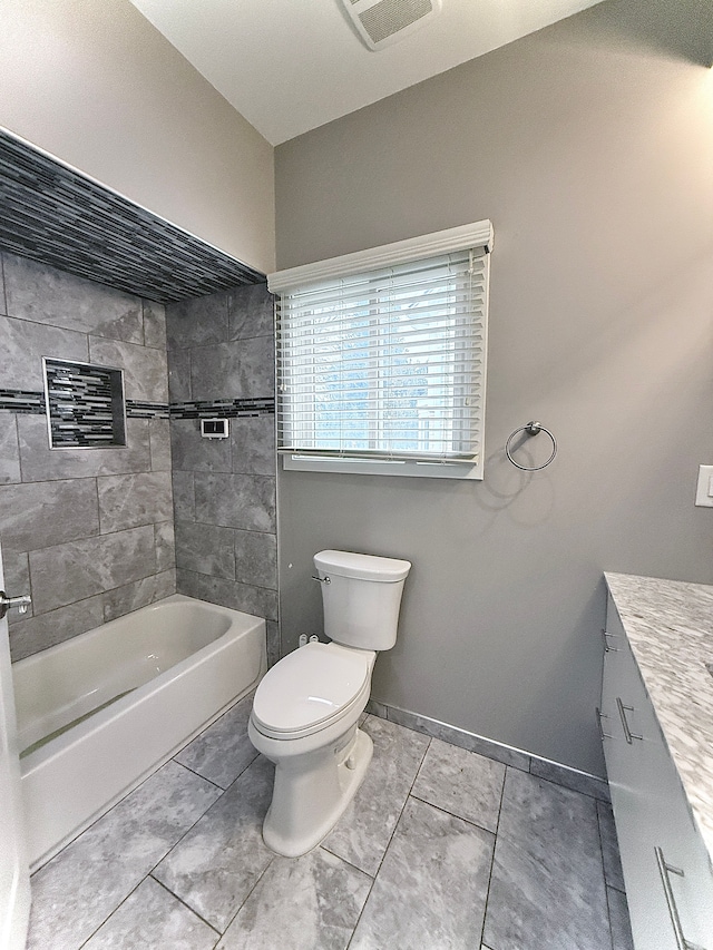 full bathroom featuring vanity, toilet, tiled shower / bath combo, and tile patterned flooring