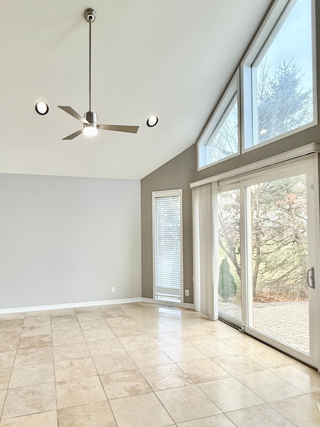 spare room with light tile patterned flooring, ceiling fan, and high vaulted ceiling