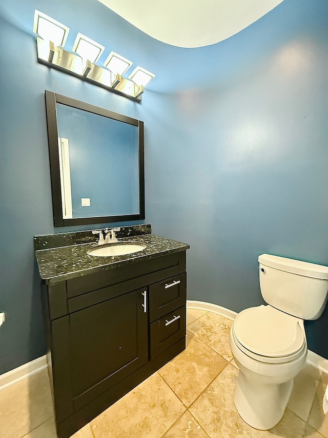 bathroom featuring vanity, tile patterned floors, and toilet