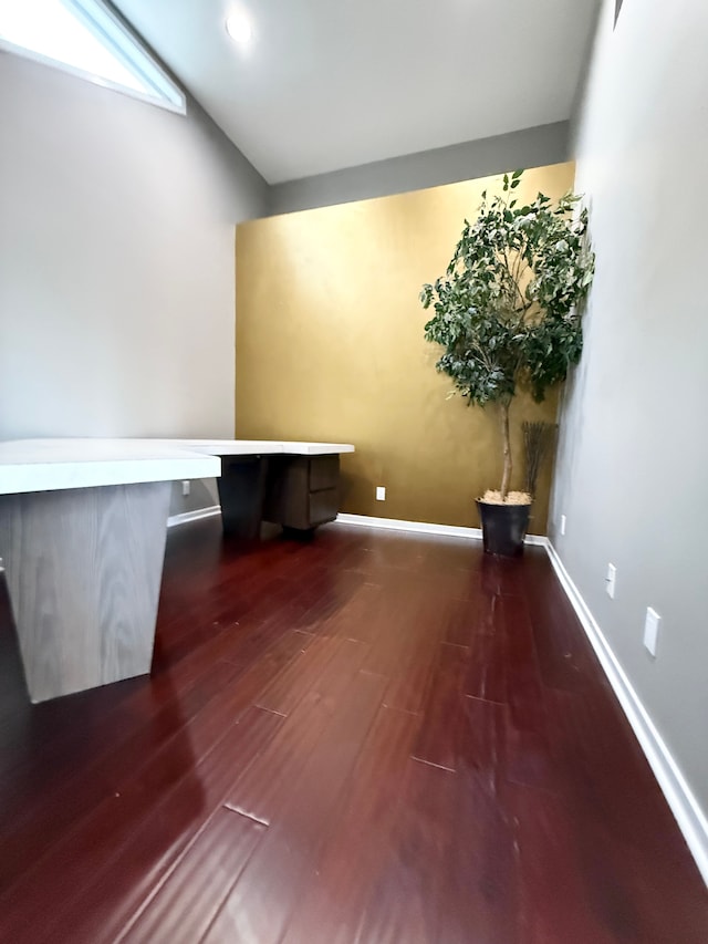 unfurnished office with dark hardwood / wood-style flooring and lofted ceiling