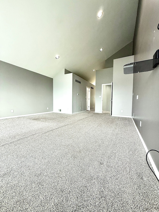 carpeted empty room with vaulted ceiling