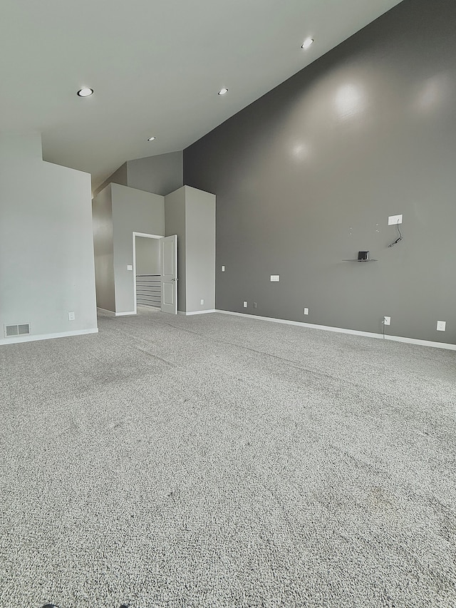 unfurnished room featuring carpet and high vaulted ceiling