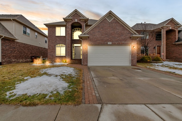 view of front of property featuring an attached garage, concrete driveway, and brick siding