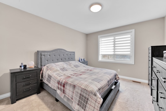 bedroom with light carpet, visible vents, and baseboards