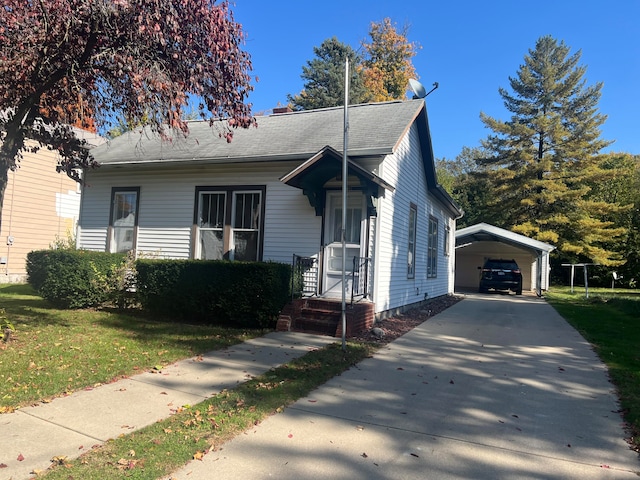 bungalow featuring a front lawn and a carport