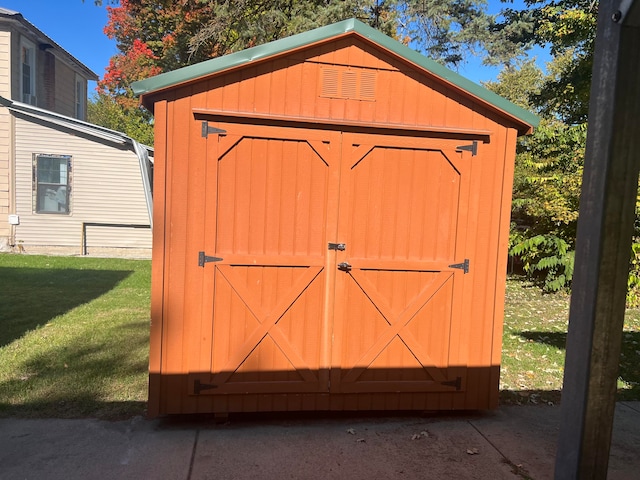 view of outbuilding featuring a lawn