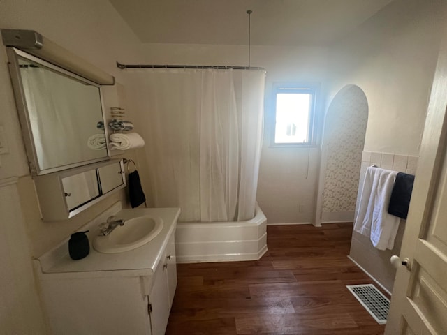 bathroom featuring hardwood / wood-style floors, vanity, and shower / bath combo with shower curtain