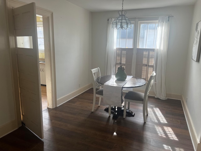 dining room featuring dark hardwood / wood-style flooring, an inviting chandelier, and a wealth of natural light