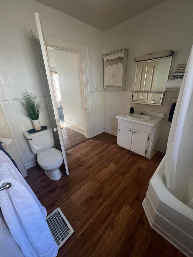 full bathroom with shower / bath combination with curtain, vanity, wood-type flooring, and toilet