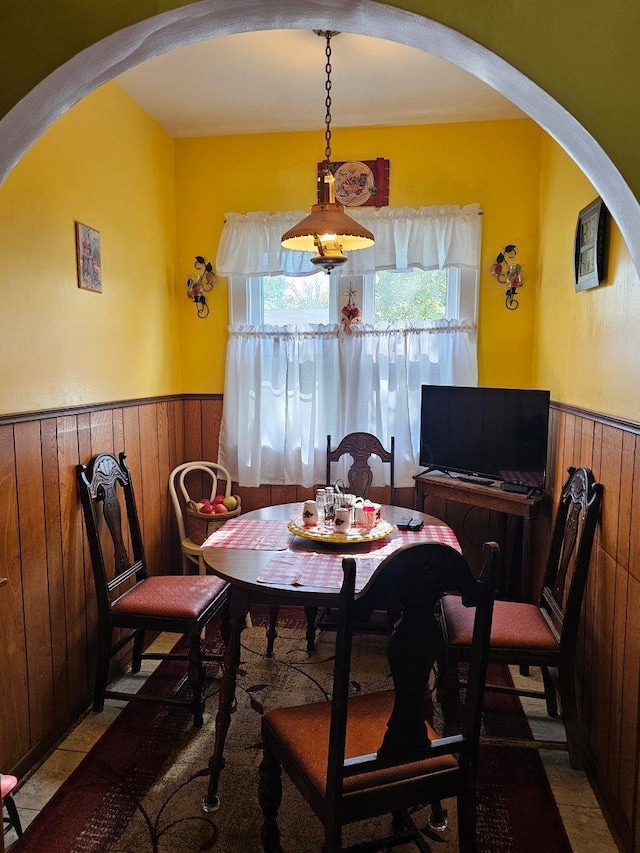 dining room featuring wooden walls and a healthy amount of sunlight