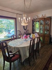 dining area with hardwood / wood-style floors and a notable chandelier