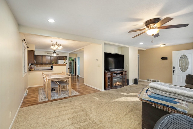 living room with light hardwood / wood-style floors and ceiling fan