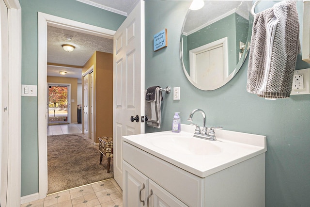 bathroom with a textured ceiling, vanity, and ornamental molding