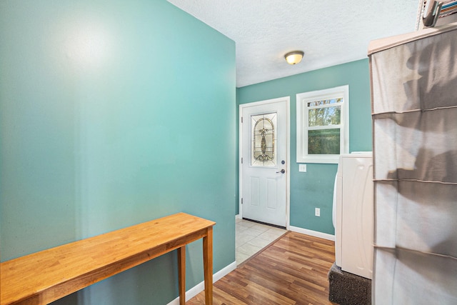 entryway featuring a textured ceiling and light hardwood / wood-style flooring