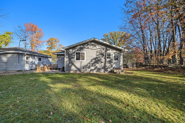 rear view of property featuring a patio area and a yard