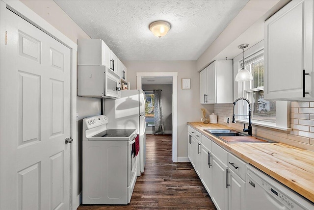 kitchen with white cabinetry, sink, hanging light fixtures, white appliances, and washer / dryer