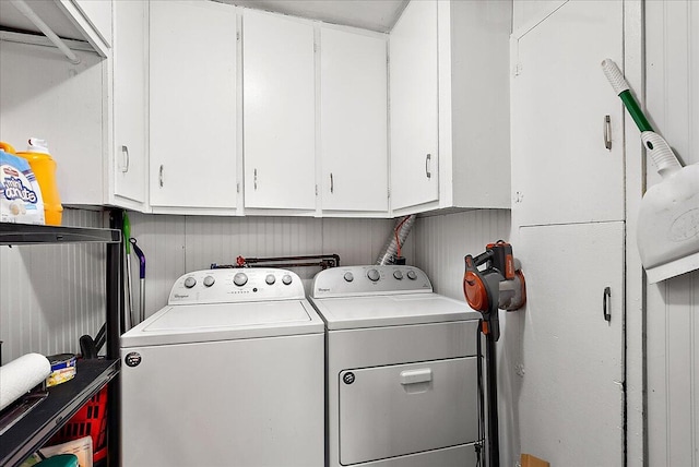 clothes washing area with cabinets and separate washer and dryer