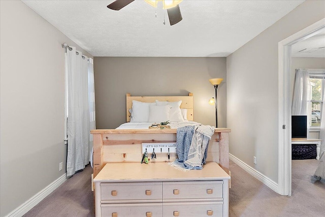 bedroom featuring a textured ceiling, carpet floors, and ceiling fan