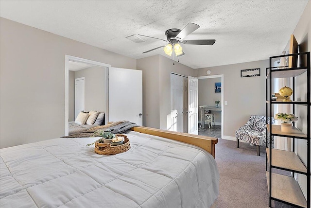 carpeted bedroom featuring a textured ceiling, a closet, and ceiling fan