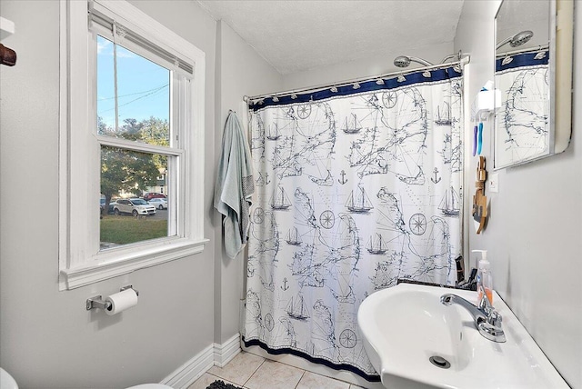 bathroom with tile patterned flooring, a textured ceiling, and curtained shower