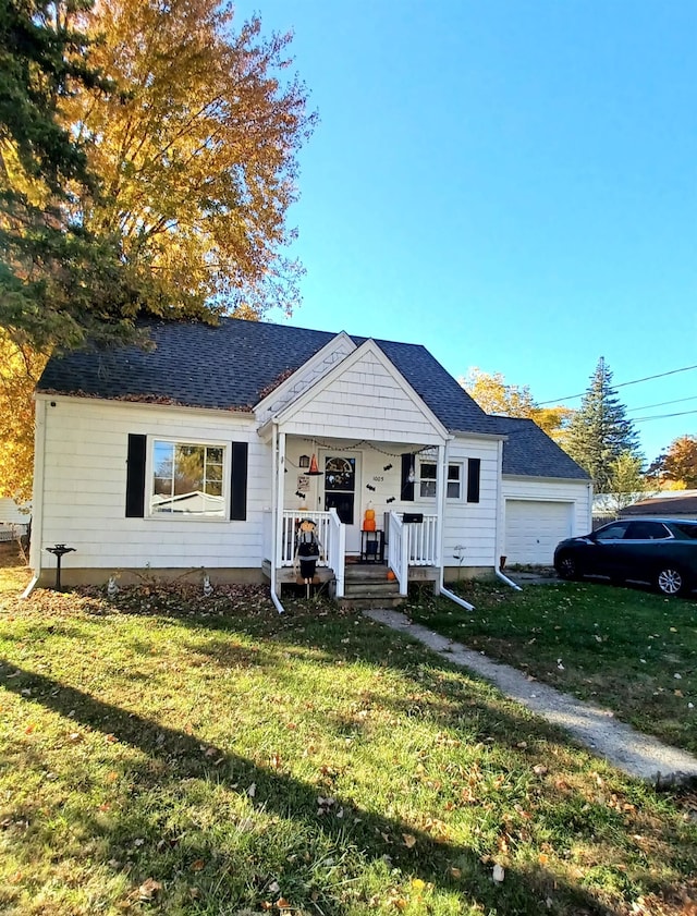 view of front of property featuring covered porch, a garage, and a front lawn