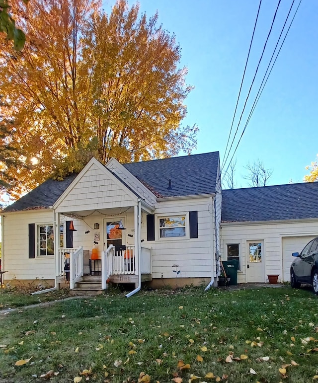 view of front facade with a porch, a front yard, and a garage