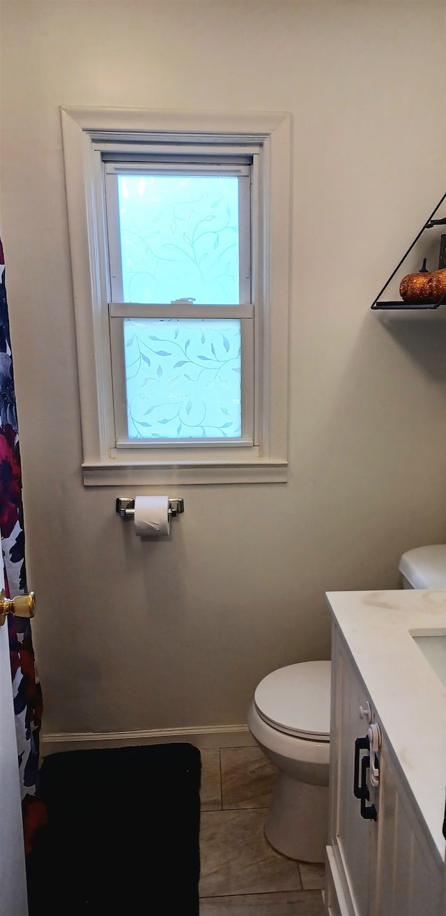 bathroom with tile patterned flooring, vanity, and toilet