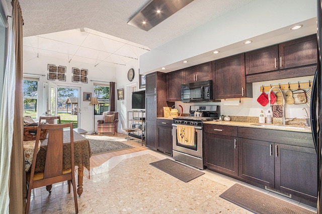 kitchen with dark brown cabinets, light hardwood / wood-style flooring, a textured ceiling, and stainless steel gas range