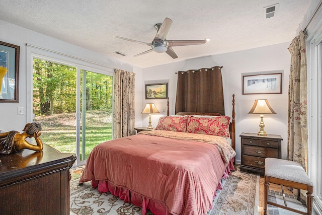 bedroom featuring access to exterior, a textured ceiling, and ceiling fan