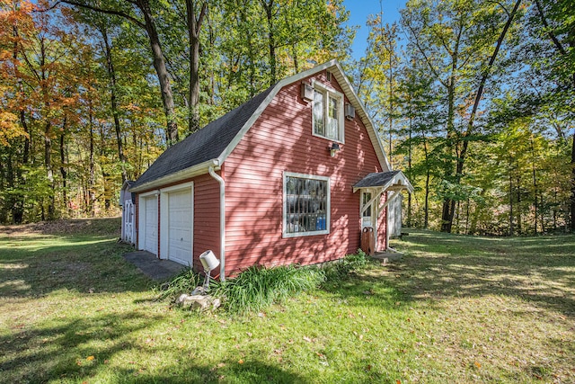 exterior space with a garage, an outdoor structure, and a yard