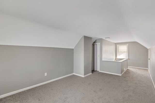 bonus room featuring light colored carpet and vaulted ceiling