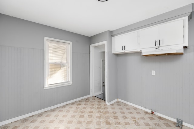 laundry area with wood walls