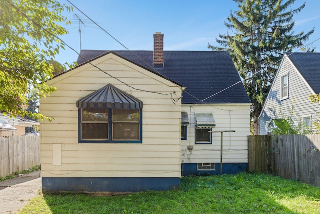 back of house with a lawn