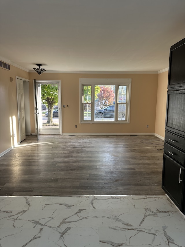 unfurnished living room featuring hardwood / wood-style flooring and crown molding