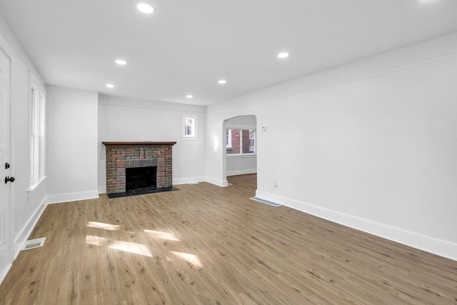 unfurnished living room with a fireplace and light hardwood / wood-style flooring