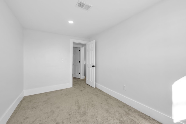 spare room featuring light colored carpet