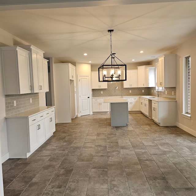 kitchen featuring a notable chandelier, white cabinetry, decorative light fixtures, and a center island