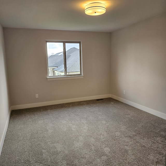 unfurnished room featuring a mountain view and carpet flooring