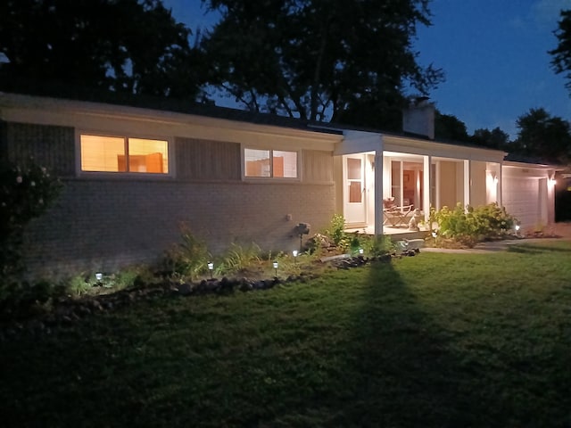 view of front of home with a yard and a garage