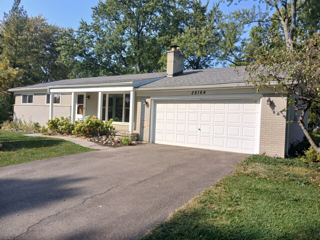 28164 Kendallwood Dr, Farmington Hills, MI 48334 - single story home with brick siding, a chimney, asphalt driveway, and a garage