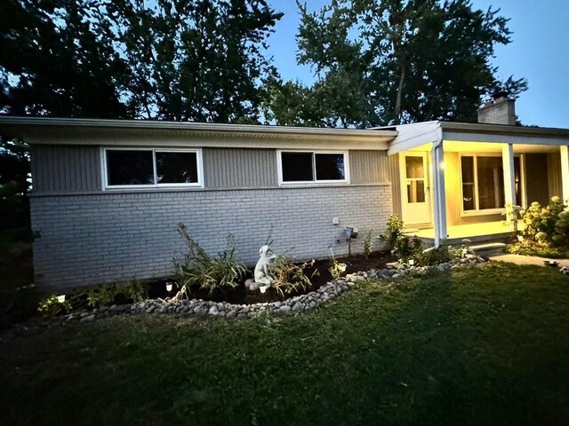28164 Kendallwood Dr, Farmington Hills, MI 48334 - view of property exterior featuring brick siding, a chimney, and a yard