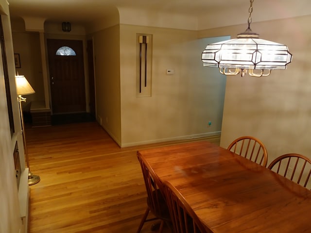 dining space with light hardwood / wood-style flooring and a notable chandelier