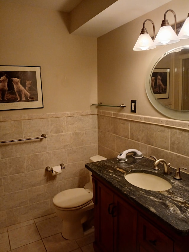 bathroom with tile patterned floors, vanity, toilet, and tile walls